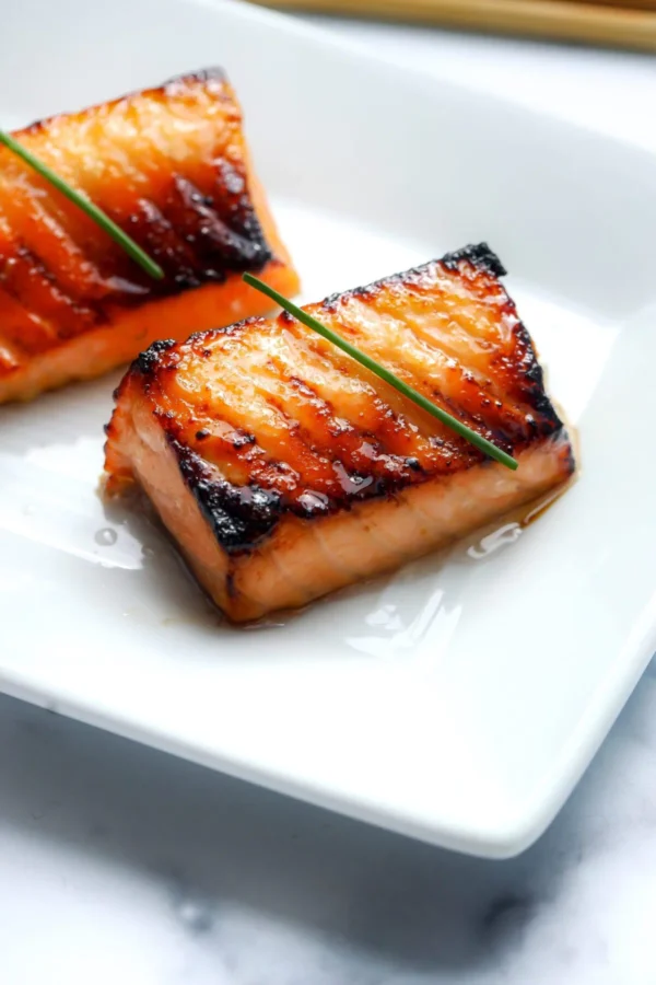 Miso salmon Nobu copycat fillets with a caramelized amber crust and tender pink interior, garnished with chives.