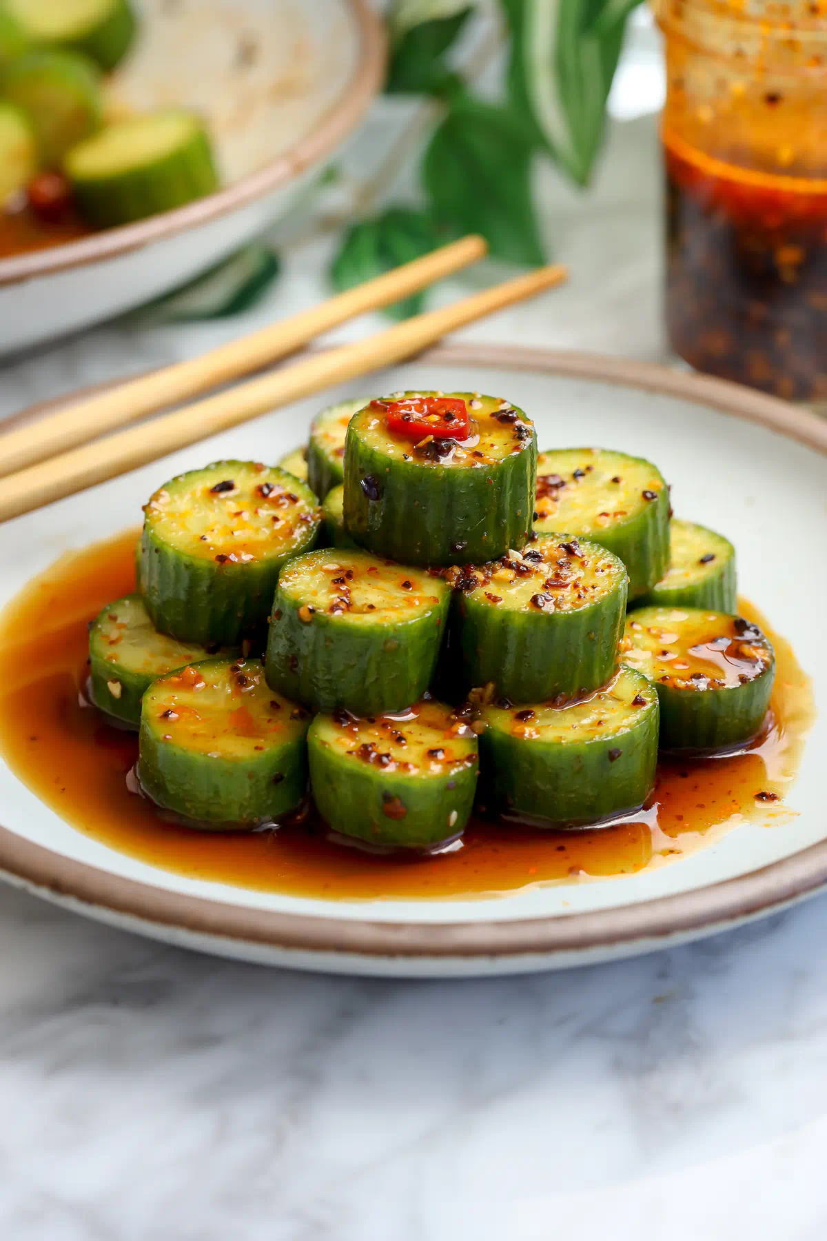 Marinated cucumber salad with soy, sesame oil, garlic, and chili, stacked and spooned with marinade overhead