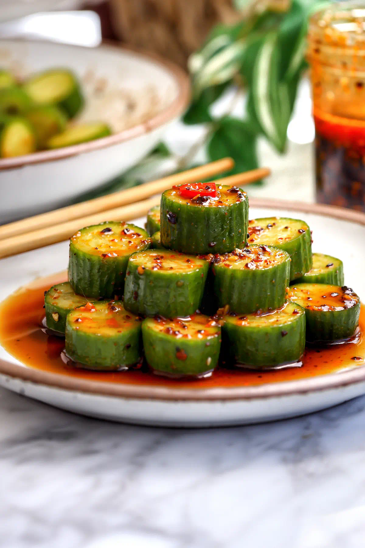 Marinated cucumber salad with soy, sesame oil, garlic, and chili, stacked and spooned with marinade