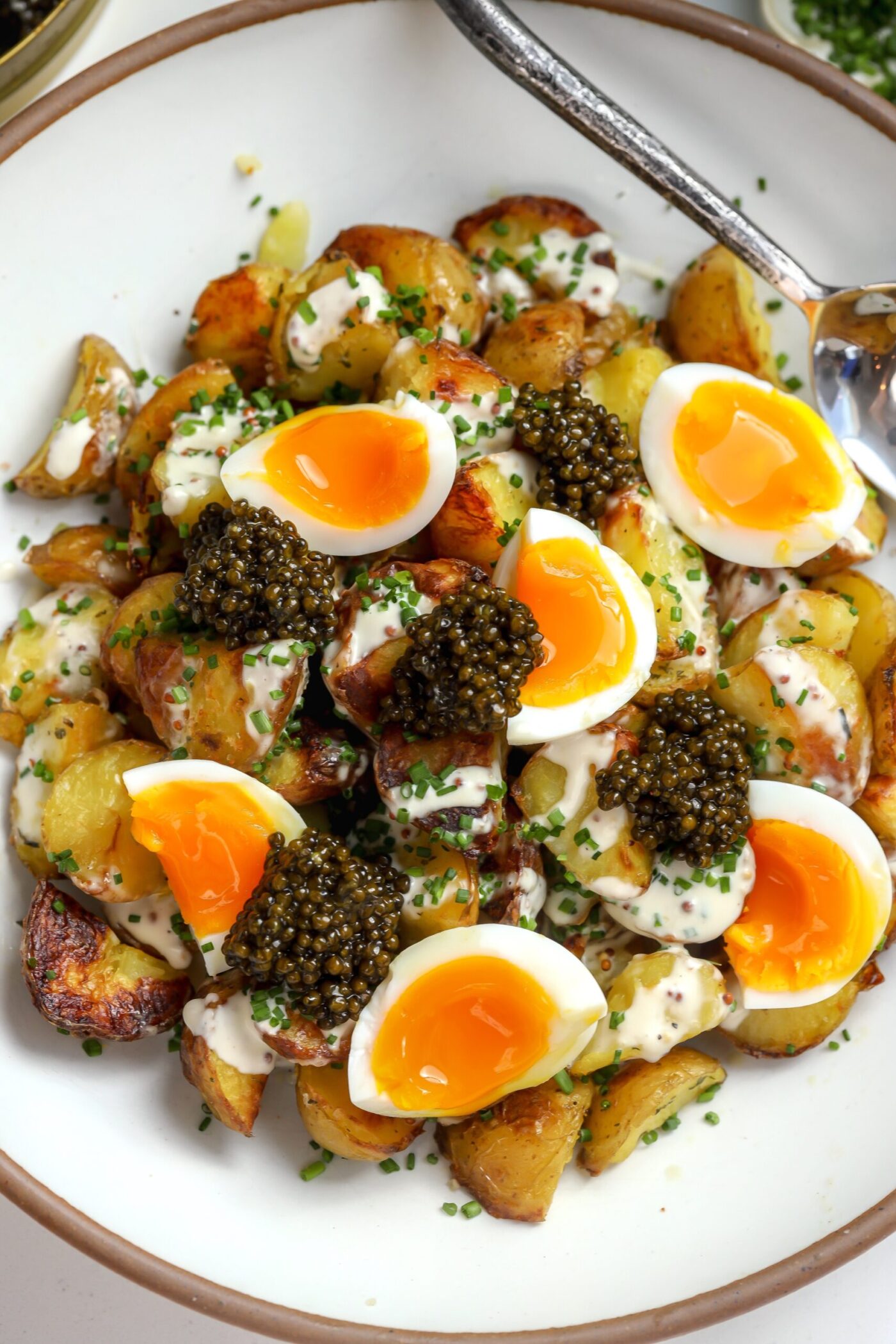 Crispy potatoes with a creamy sauce, jammy eggs and caviar.