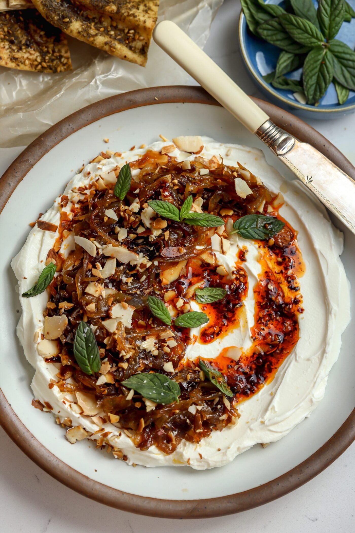 a delicious labneh dip with za'atar, salsa macha, almost and caramelized French onions on top.