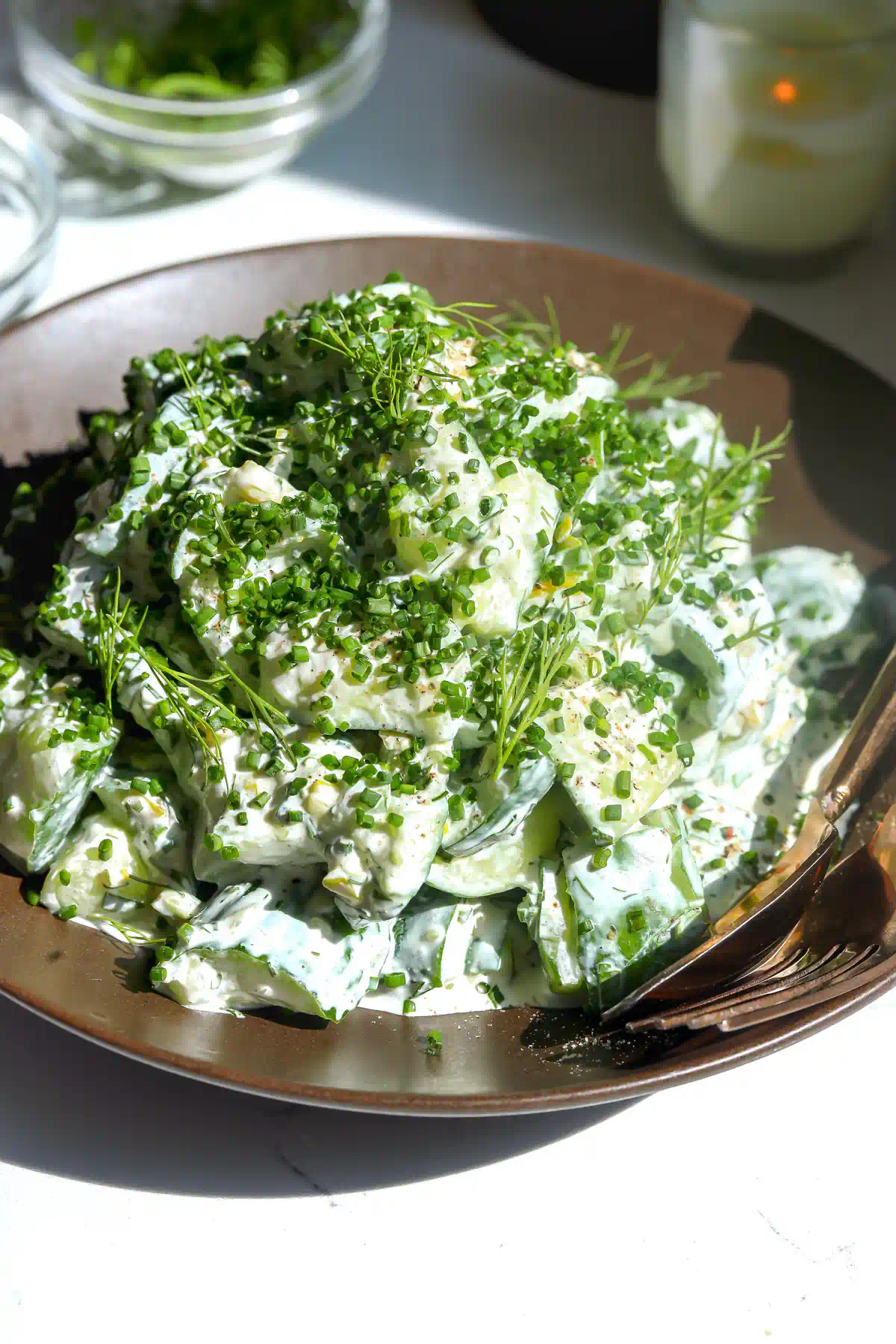 smashed persian cucumber chunks coated in creamy pepperoncini ranch dressing, topped with chives and dill