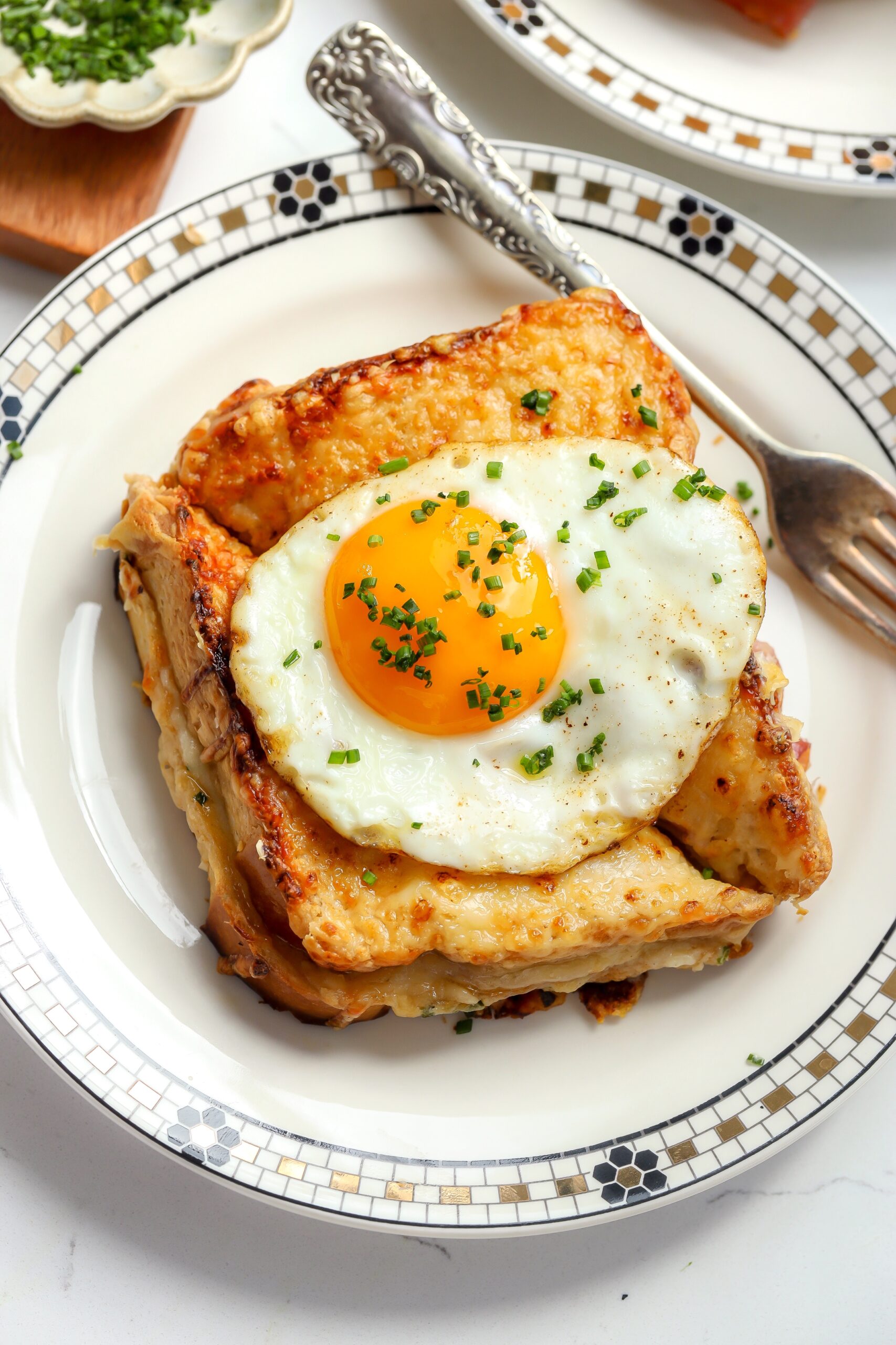 croque madame sandwich recipe on brioche with a fried egg on top.