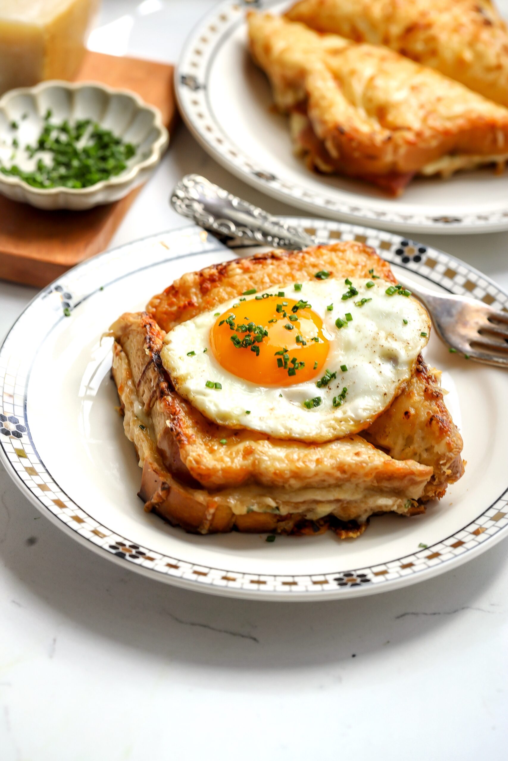 croque madame sandwich recipe on brioche with a fried egg on top.