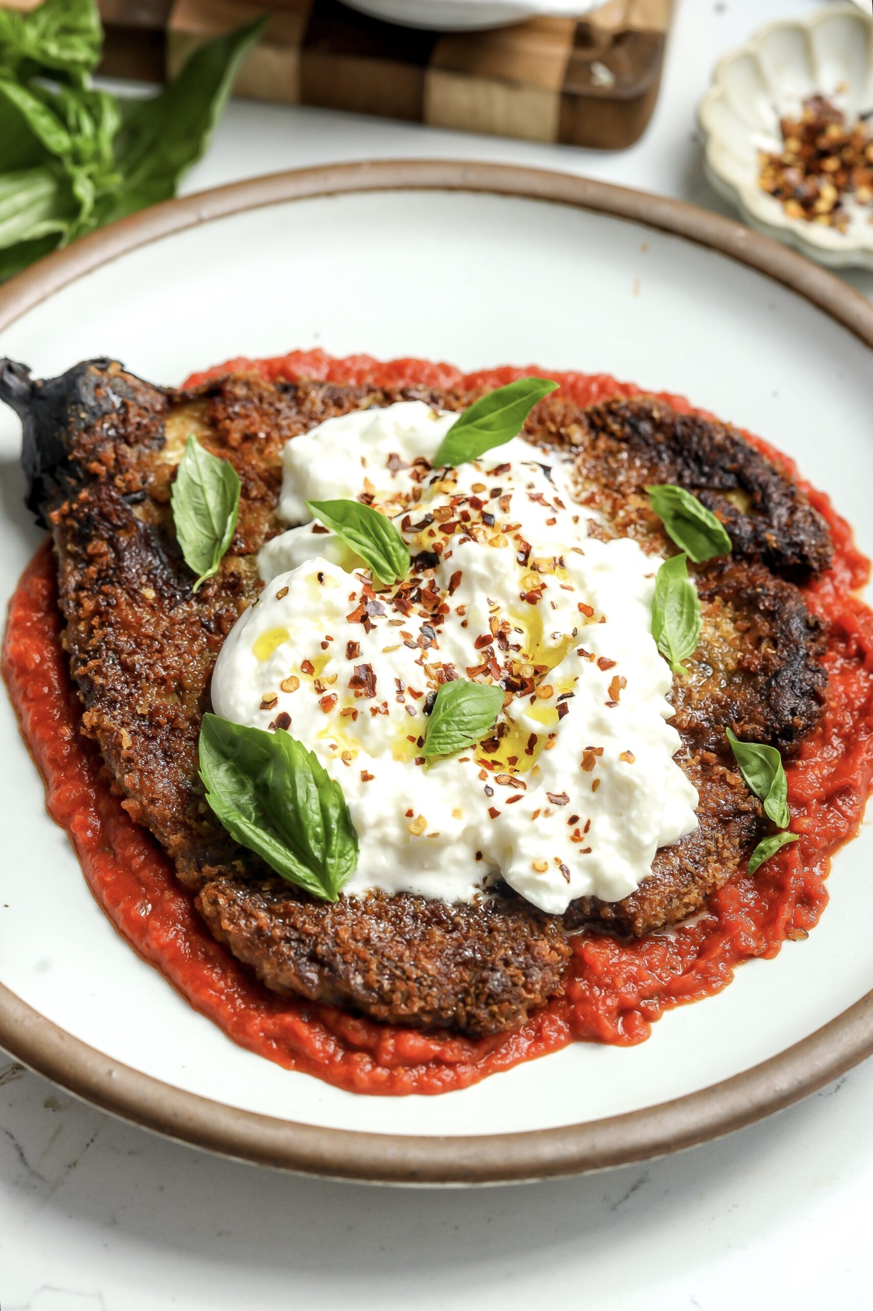 whole roasted eggplant parmesan on top of a tomato sauce made from scratch and covered in burrata.