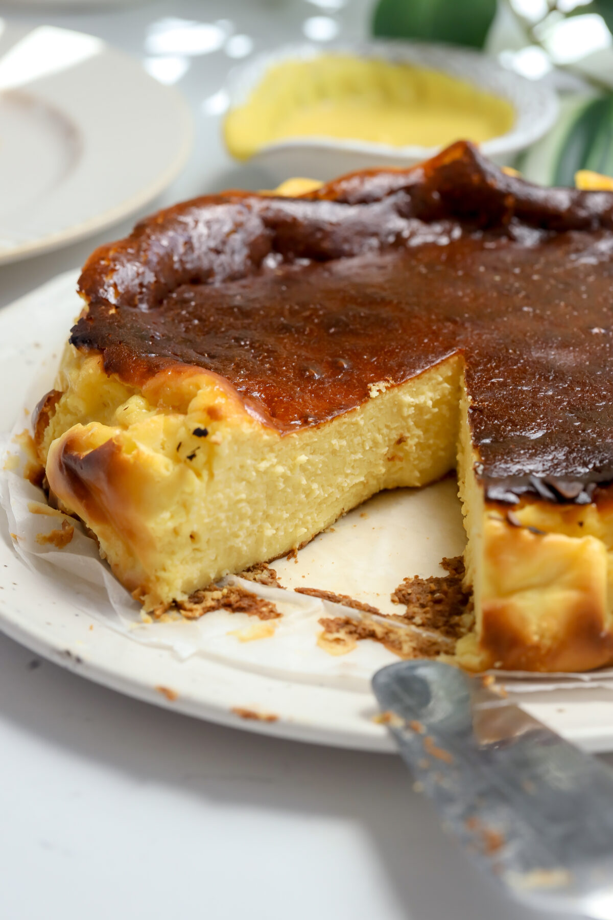 A caramelized burnt Basque corn cheesecake recipe with a slice taken out to show the creamy center.