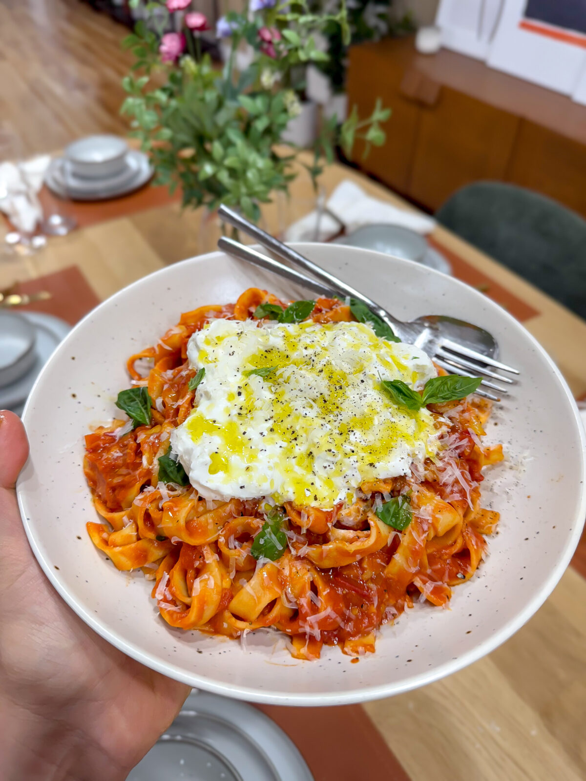 Cherry Tomato spaghetti sauce with Pasta and Burrata spread on top. Basil and a drizzle of olive oil for topping.
