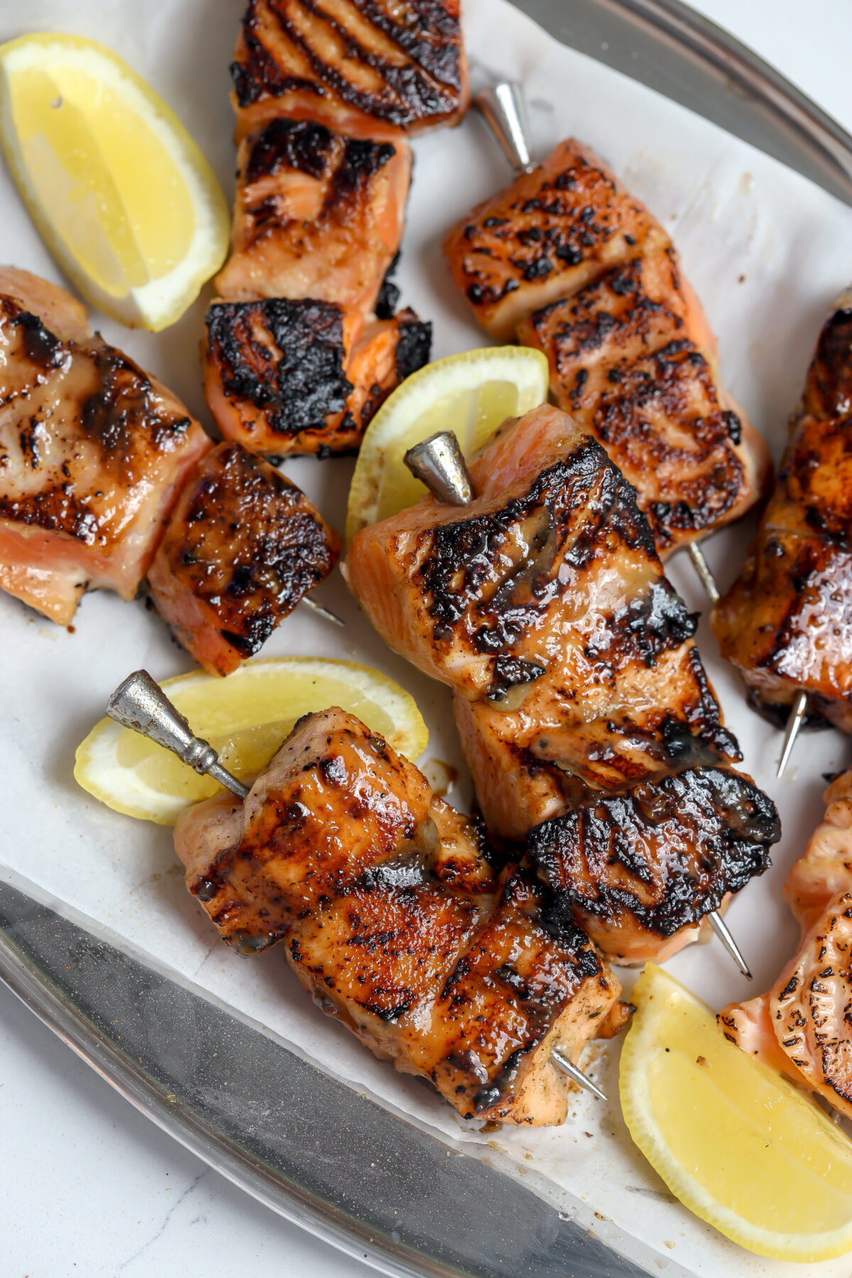 A recipe for Miso glazed salmon skewers on a bed of rice next to sliced lemon.