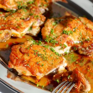 Crispy chicken thighs seared in a skillet and covered in a sake butter sauce.