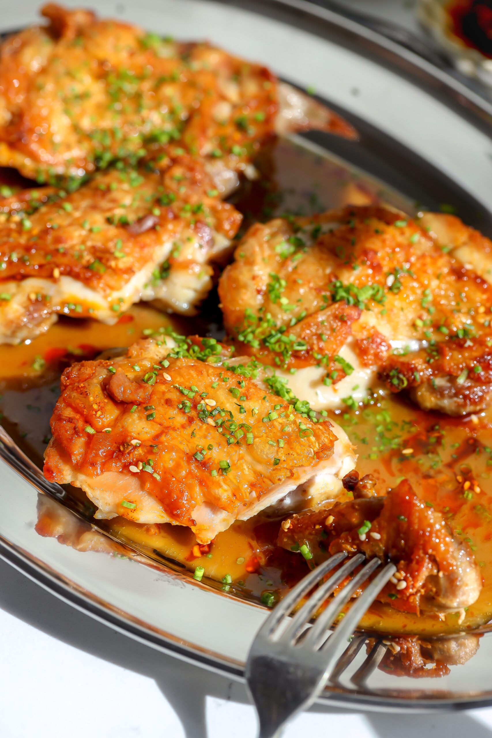 Crispy chicken thighs seared in a skillet and covered in a sake butter sauce.