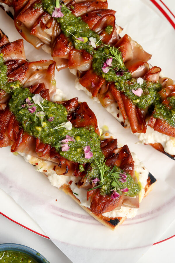 Mortadella Tartine with a homemade Stracciatella & Pistachio sauce on a plate.