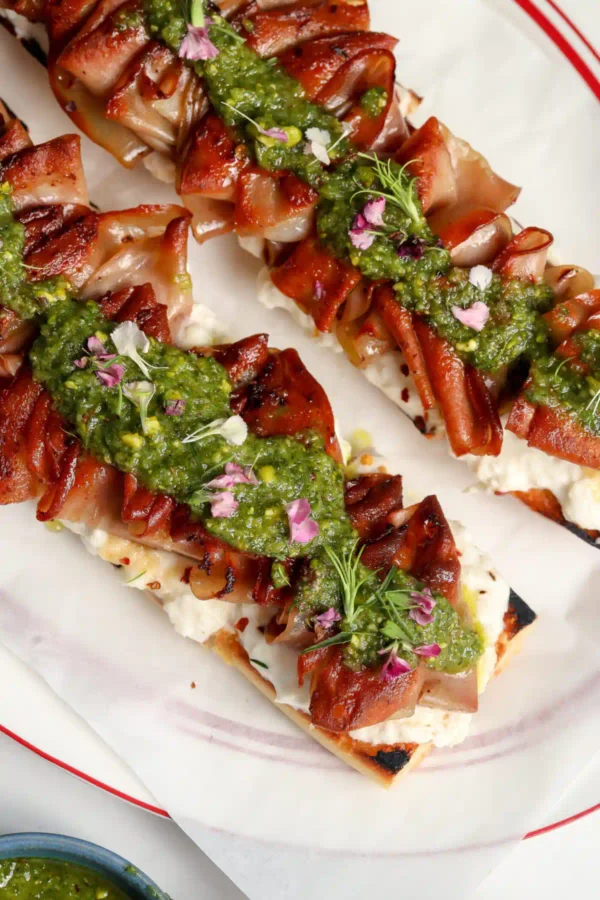 Mortadella Tartine with a homemade Stracciatella & Pistachio sauce on a plate.