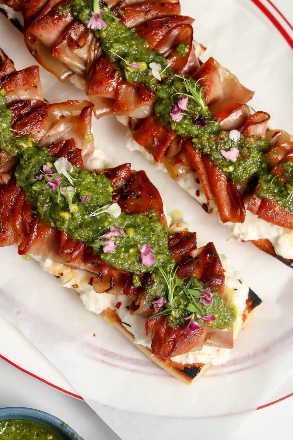 Mortadella Tartine with a homemade Stracciatella & Pistachio sauce on a plate.