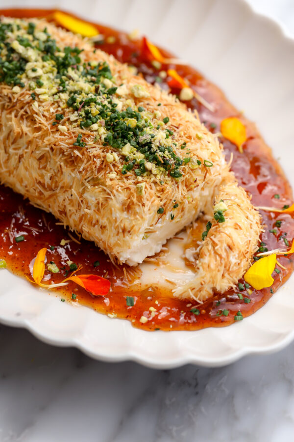 A recipe for whipped feta and cream cheese with a chipotle fig jam inside, coated in toasted kataifi on a plate.