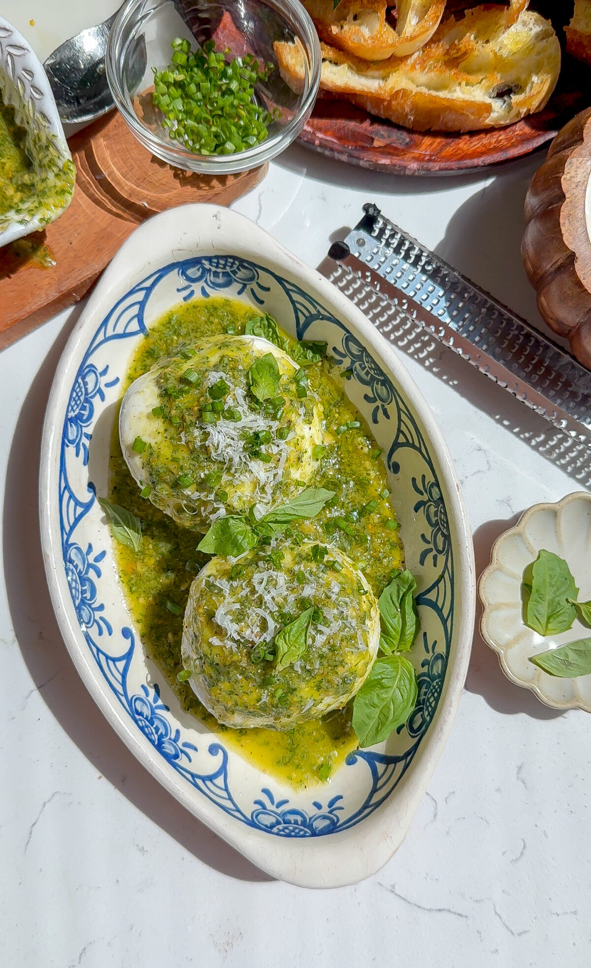 The best appetizer recipe for basil pesto on top of burrata in a plate.
