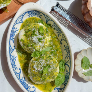 The best appetizer recipe for basil pesto on top of burrata in a plate.
