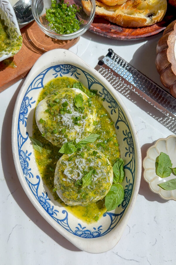 The best appetizer recipe for basil pesto on top of burrata in a plate.