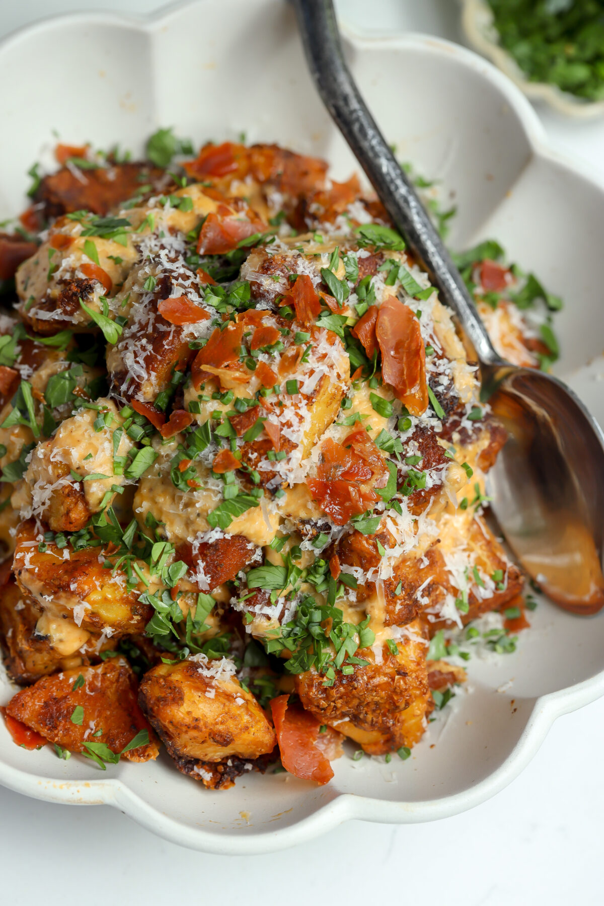 A recipe for Crispy Manchego Potatoes covered in a Creamy Chipotle Sauce, parm and chives.