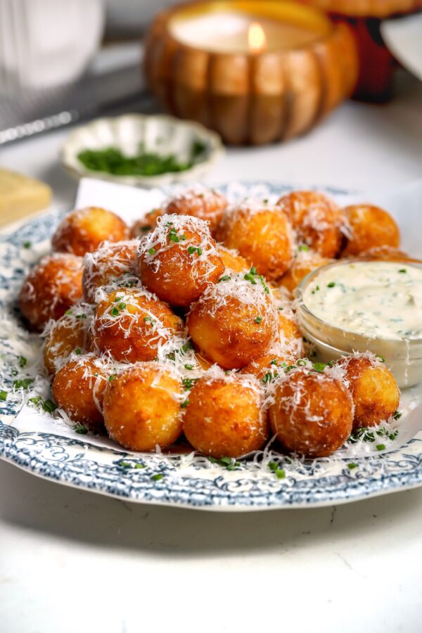 Fried Mashed Potato Balls seasoned with salt and vinegar powder with an Herb Cream Sauce in a ramekin on the side.