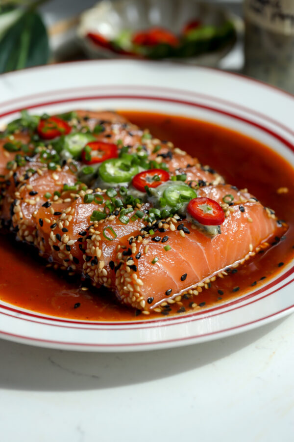Sesame coated salmon in a spicy orange sauce topped with a nori mayo and sliced chili peppers.