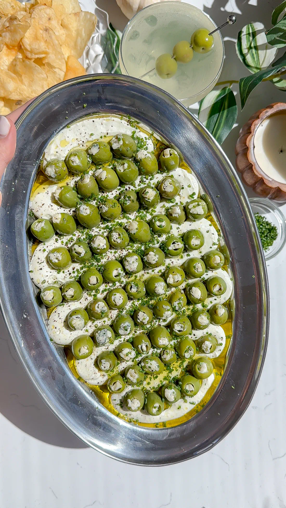 This is a blue cheese and cream cheese dip with a bunch of other savory seasonings spread on a plate and topped with blue cheese stuffed olives, the perfect dirty martini the perfect dirty martini easy make-ahead appetizer.