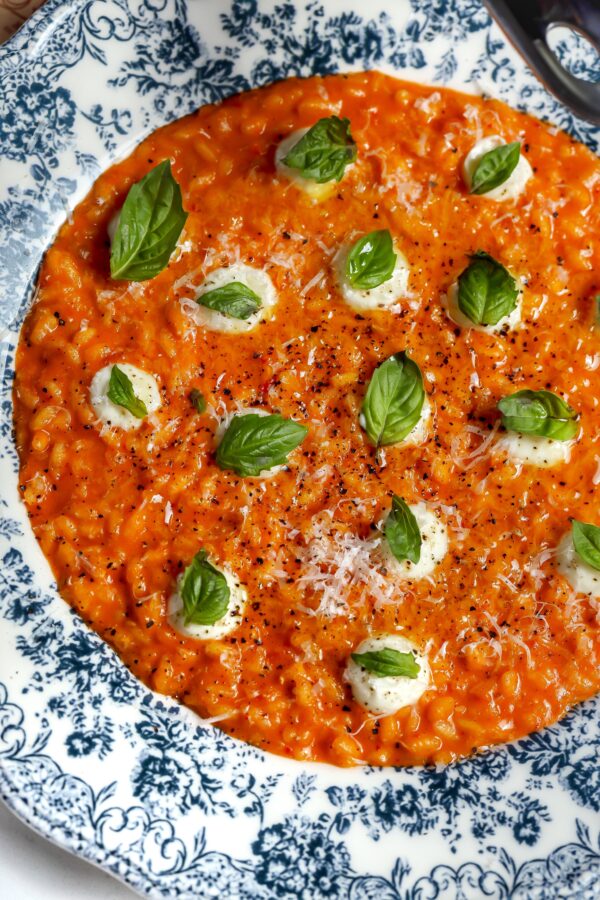 An easy creamy tomato risotto with mascarpone and basil on top in a bowl.