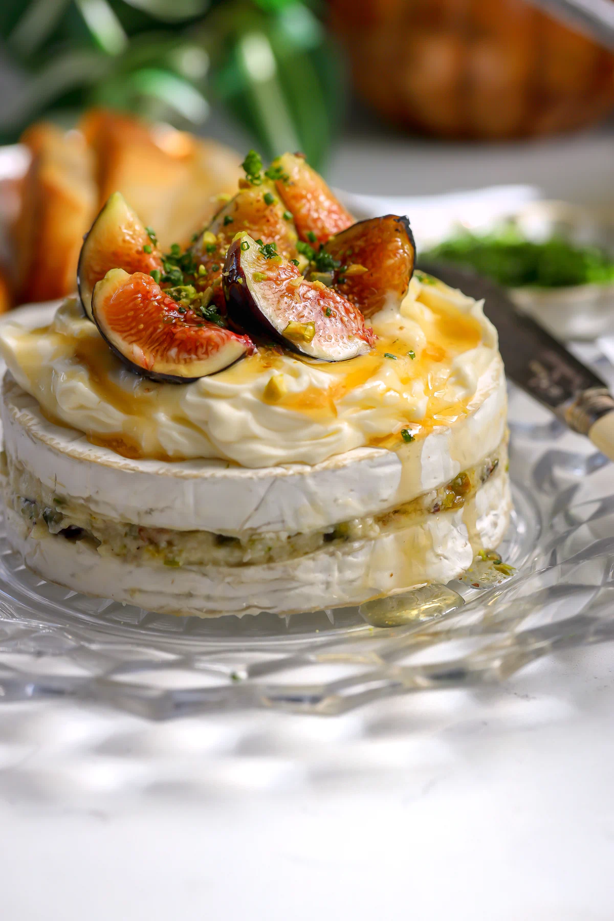 layered brie wheel with pistachios and fig jam. Topped with fresh figs and honey.