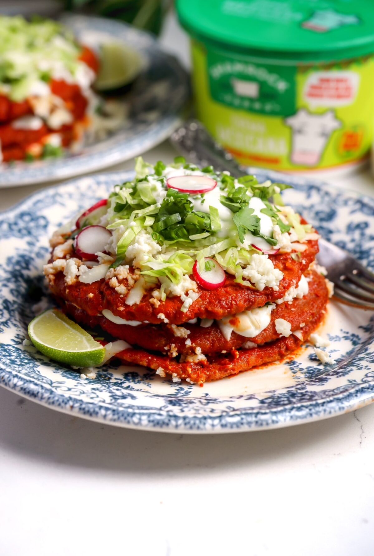 Sonoran enchiladas stacked with red chile sauce, Oaxaca cheese, queso fresco, Mexican crema and fresh toppings