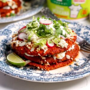 Sonoran enchiladas stacked with red chile sauce, Oaxaca cheese, queso fresco, Mexican crema and fresh toppings