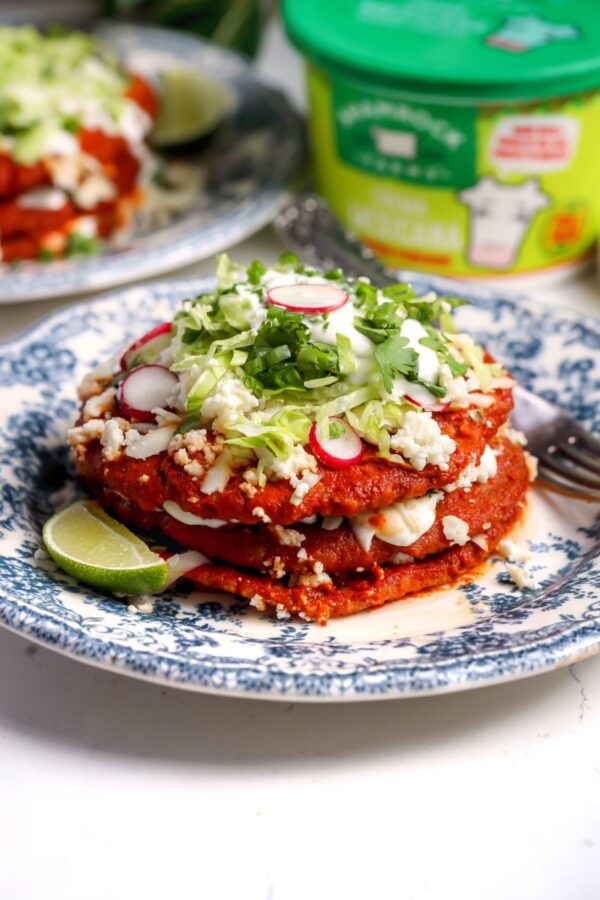 Sonoran enchiladas stacked with red chile sauce, Oaxaca cheese, queso fresco, Mexican crema and fresh toppings
