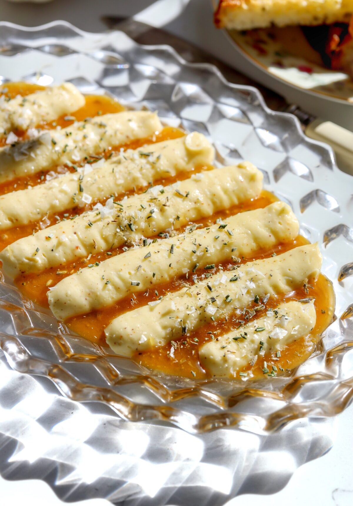 Whipped brie appetizer on a platter with creamed lavender honey, rosemary, and flaky salt, ready to serve with warm bread.