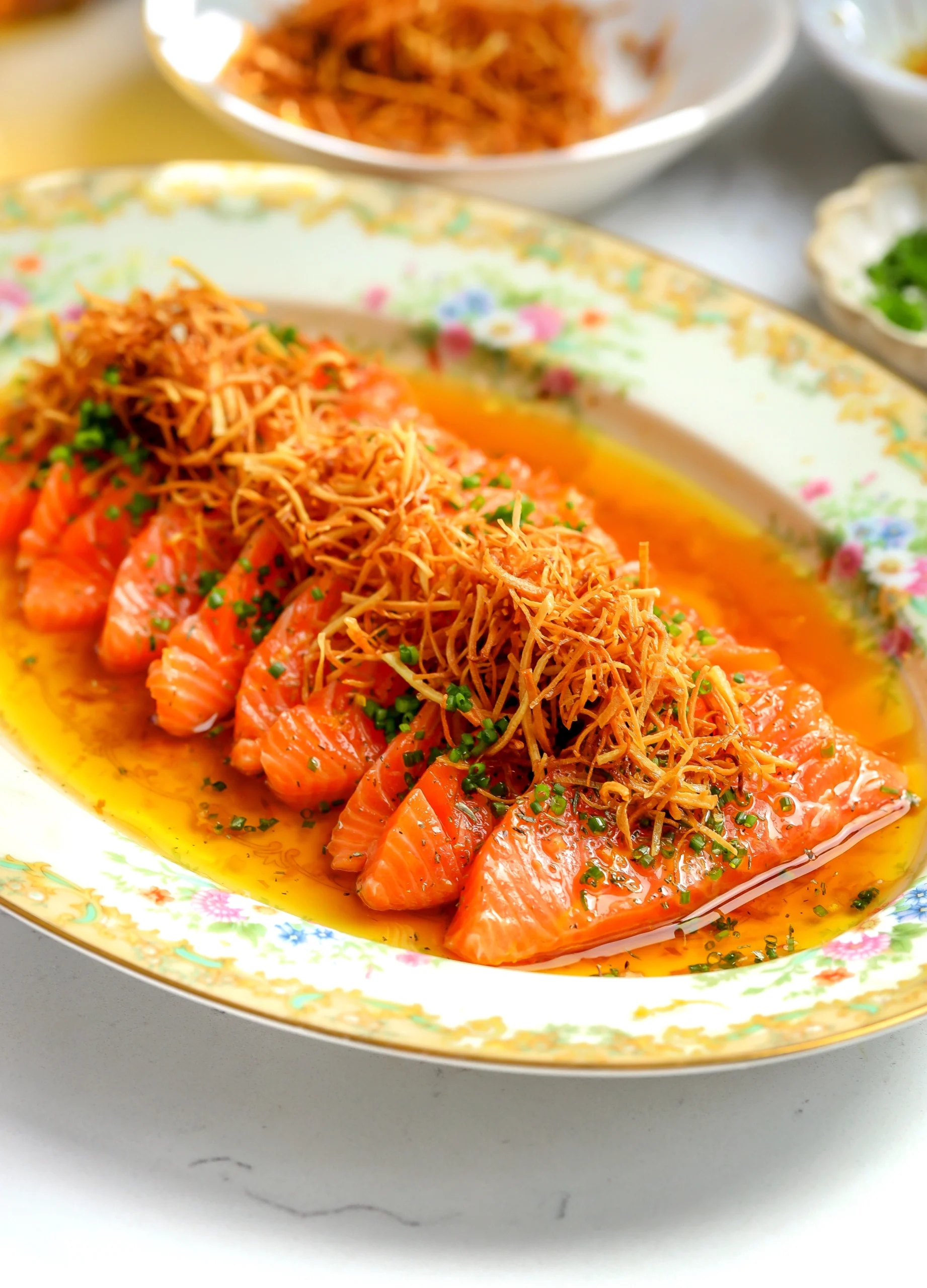 Thinly sliced salmon crudo dressed in a citrusy yuzu ponzu and topped with crispy parsnips and fresh chives.