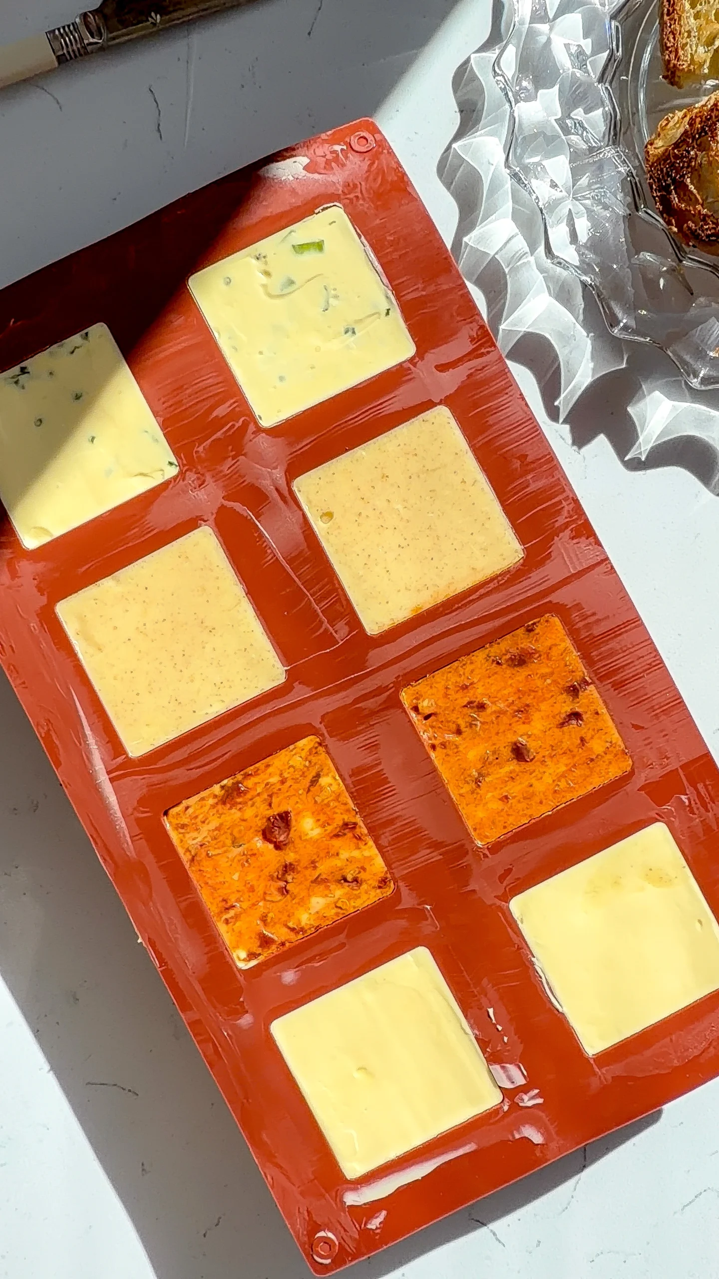 Four compound butter cubes set in a silicone mold before unmolding