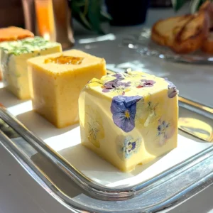 Goat cheese and fig compound butter cube decorated with edible flowers