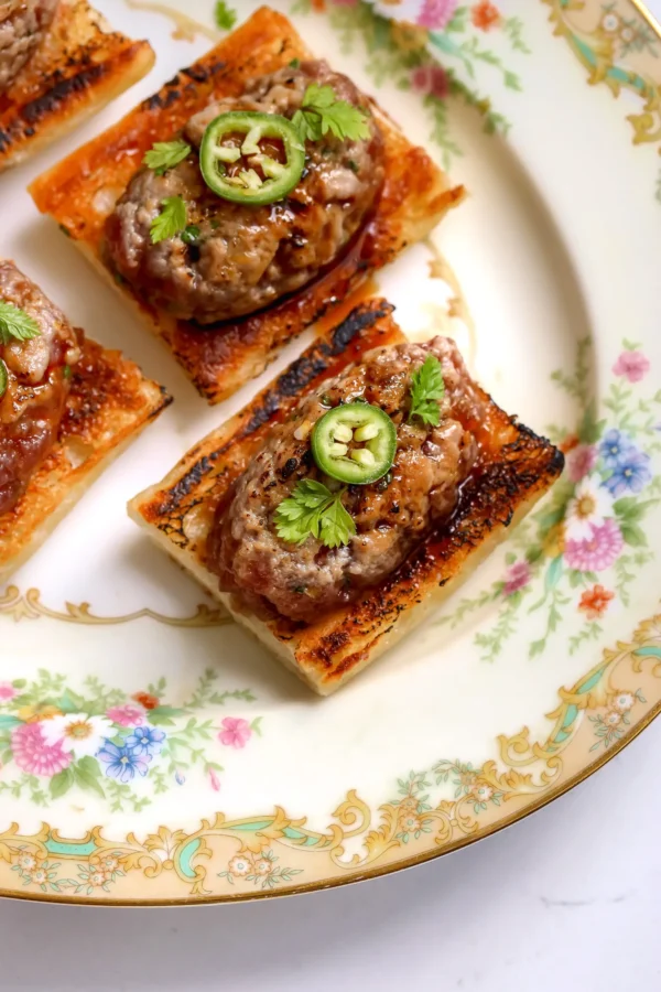 Overhead view of tuna tartare on toasted baguette with serrano and herbs