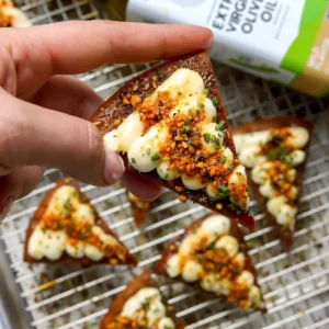 Whipped feta crostini made with fried pita, piped whipped feta, and pistachio salsa macha