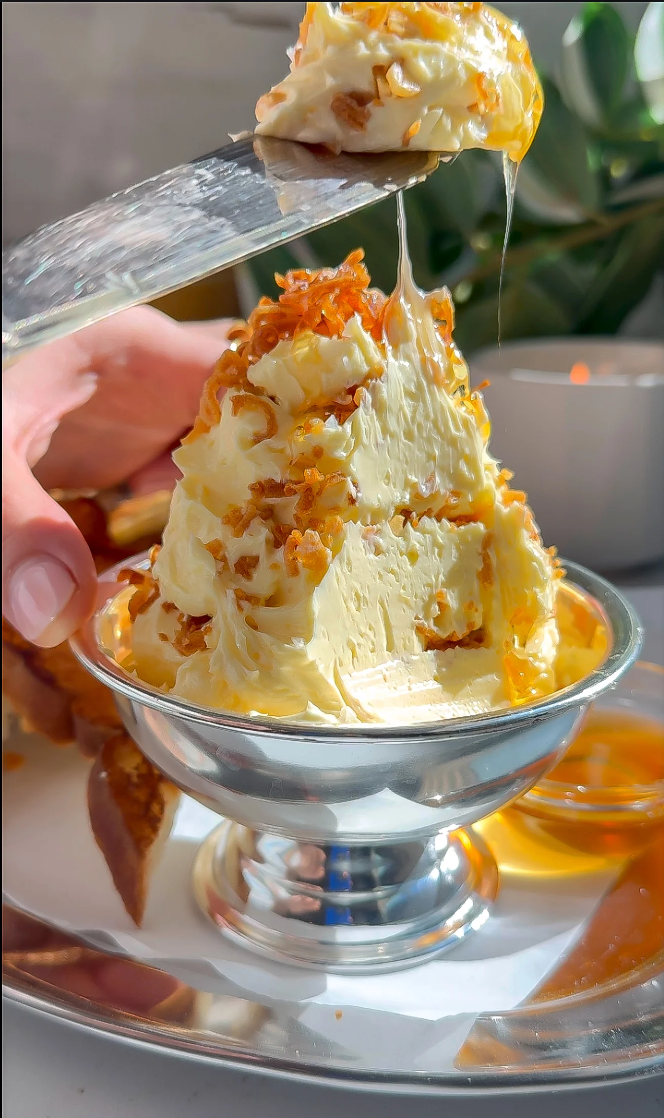 Knife lifting whipped garlic butter with crispy garlic and shallots as honey stretches from the butter