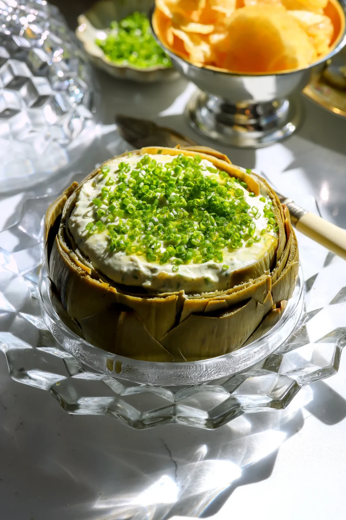 Cold artichoke dip served inside a cooked whole artichoke