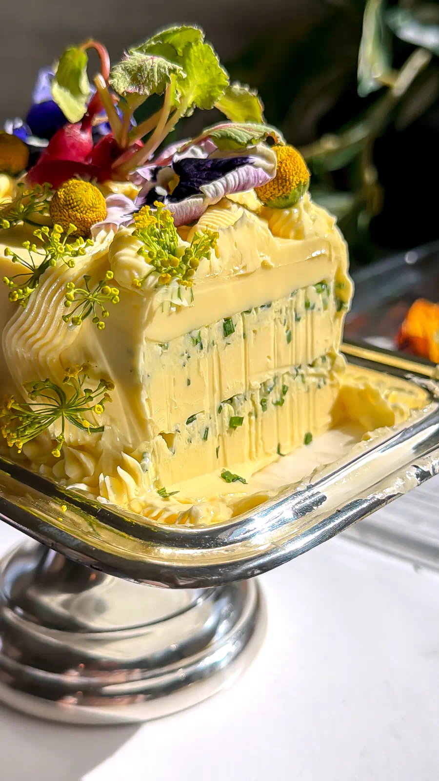 A sliced savory butter cake revealing internal layers of whipped herb and parm filling.