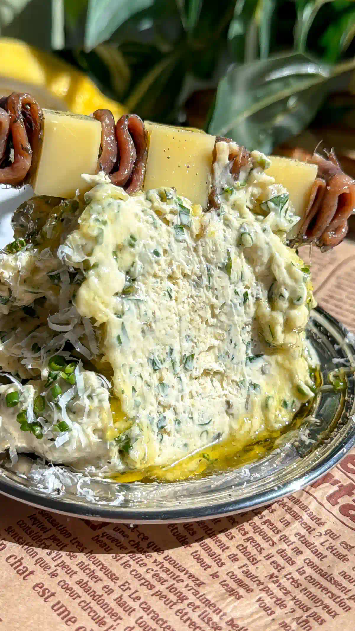 A close-up of Caesar whipped brown butter with a large scoop removed, revealing the airy, herb-speckled texture inside the butter mound.