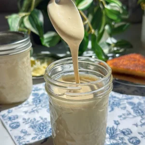 Creamy honey with the perfect cloud texture drizzling off spoon