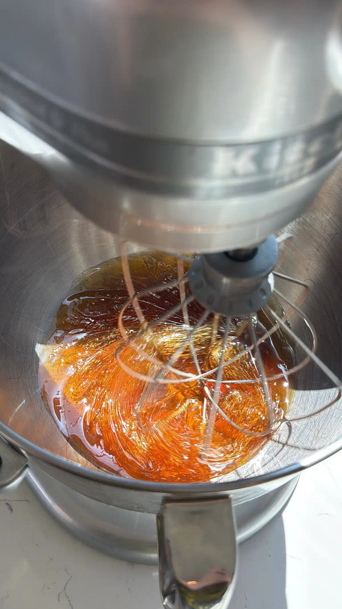 Perfectly whipped honey about to be whipped in a stand mixer with a whisk attachment