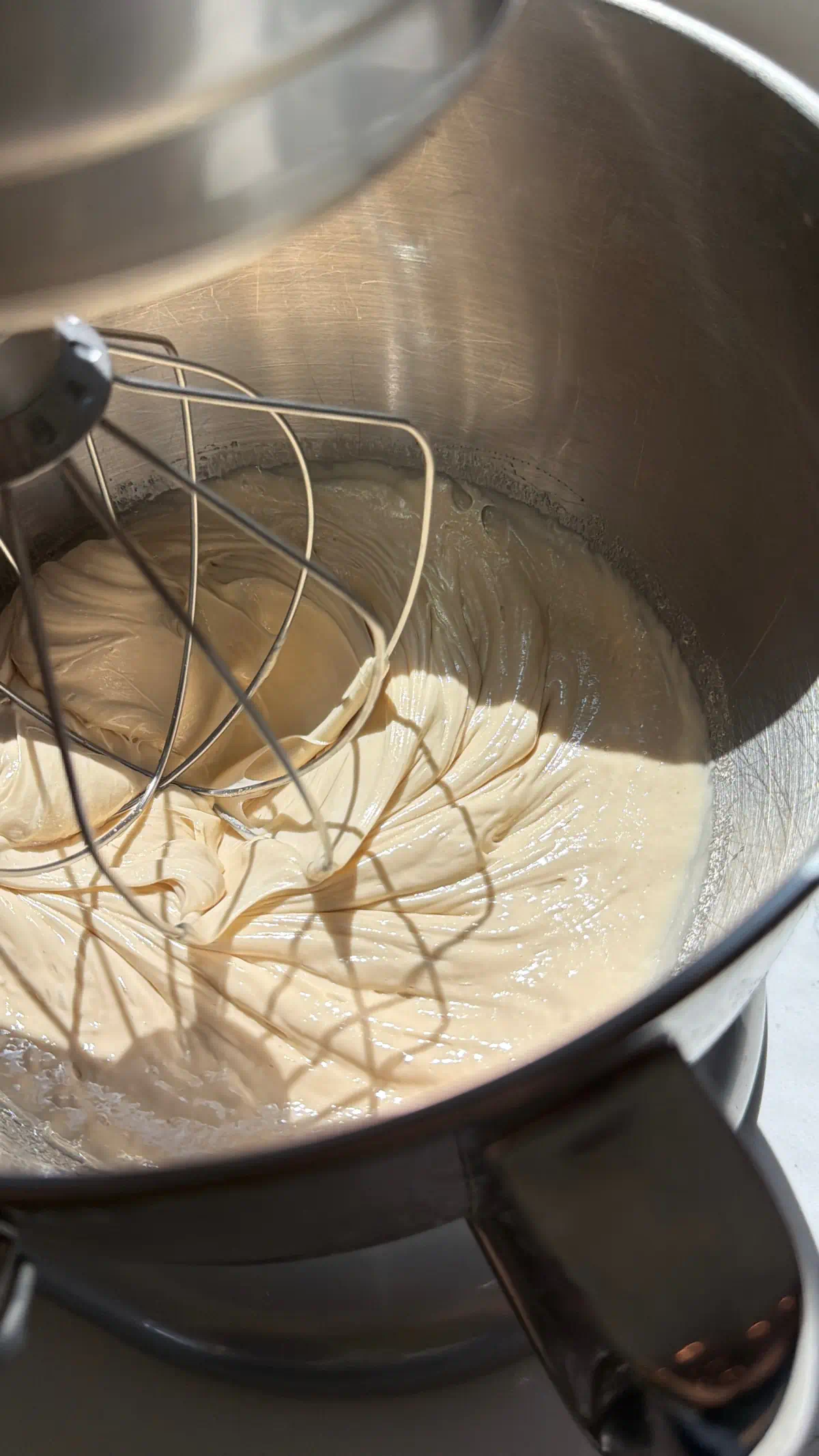 Perfectly whipped honey being whipped in a stand mixer with a whisk attachment