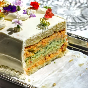 Sliced Sandwichon showing alternating layers of chipotle chicken salad and herb cheese spread between brioche bread on a silver platter.