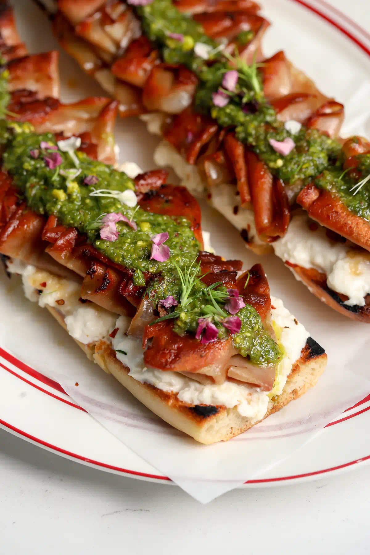 Mortadella tartine with stracciatella and pistachio sauce on toasted baguette
