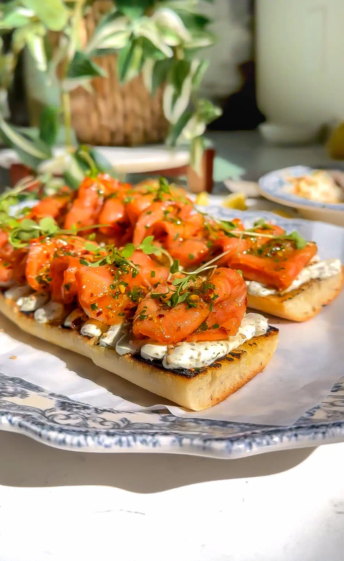 Smoked salmon tartine with whipped caper dill cream cheese and fried shallots on toasted baguette