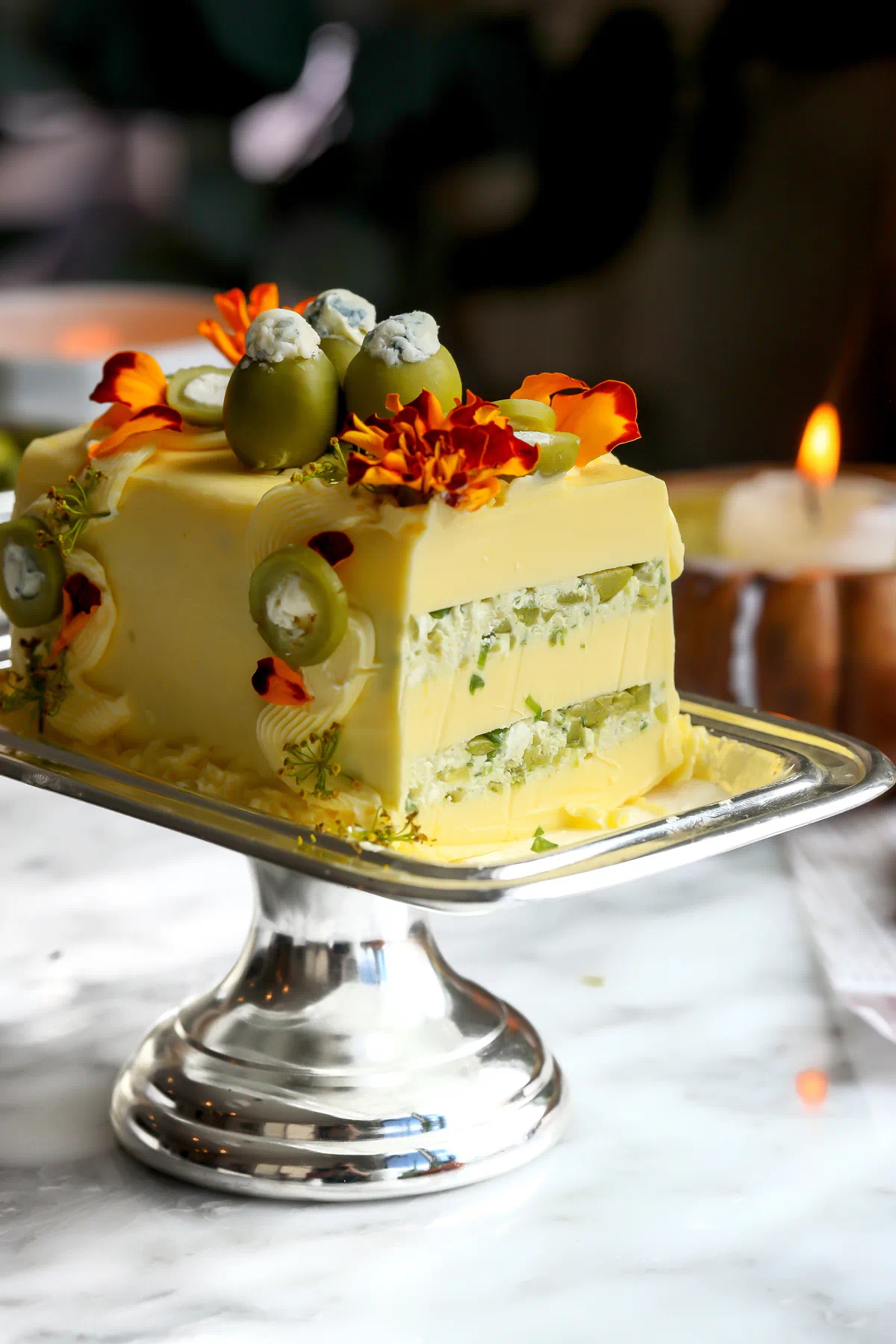 A sliced dirty martini butter cake showing two layers of olive, chive, and blue cheese filling between butter planks